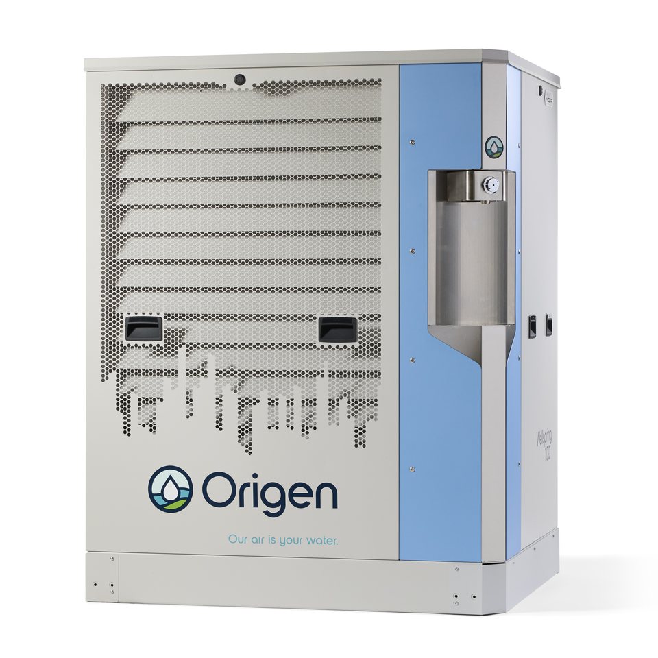 Origen Wellspring 100 atmospheric water generator kiosk — real production unit photo showing city-skyline air intake grille, one-touch stainless steel water dispense bay and weatherized enclosure